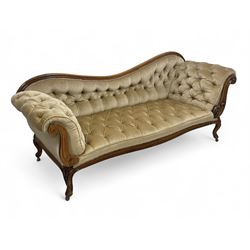 19th century walnut framed chaise longue, shaped back over scrolled arms decorated with moulded curling acanthus carvings, upholstered in deep buttoned champagne fabric, raised on cabriole supports with applied floral carved decoration, on castors