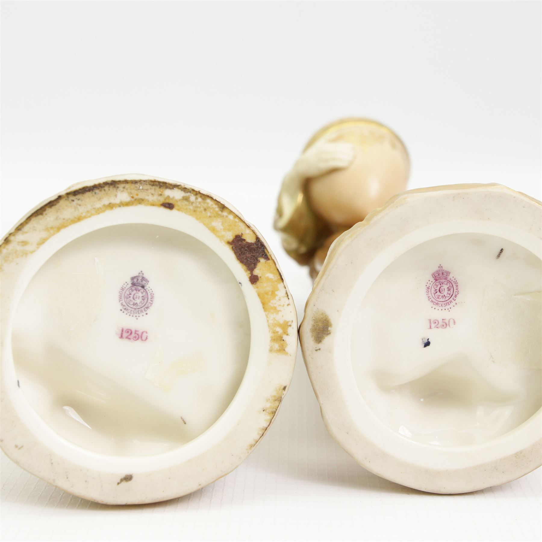 Pair of Royal Worcester figures of Egyptian water carriers after James Hadley dressed in gilt cloaks and on circular bases H24cm, number 1250, date code for 1913