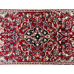 Persian crimson ground rug or mat, field decorated with central medallion and all-over scrolling floral motifs, border with repeating palmettes