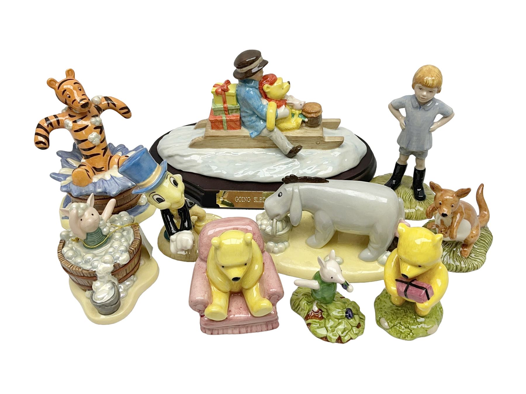 Nine Royal Doulton Winnie the Pooh Collection figures, including Oh Dear Bath Time's Here, Going Sledging, Tigger's Splash Time and Christopher Robin, together with a Royal Doulton Disney Showcase Jiminy Cricket figure, all boxed