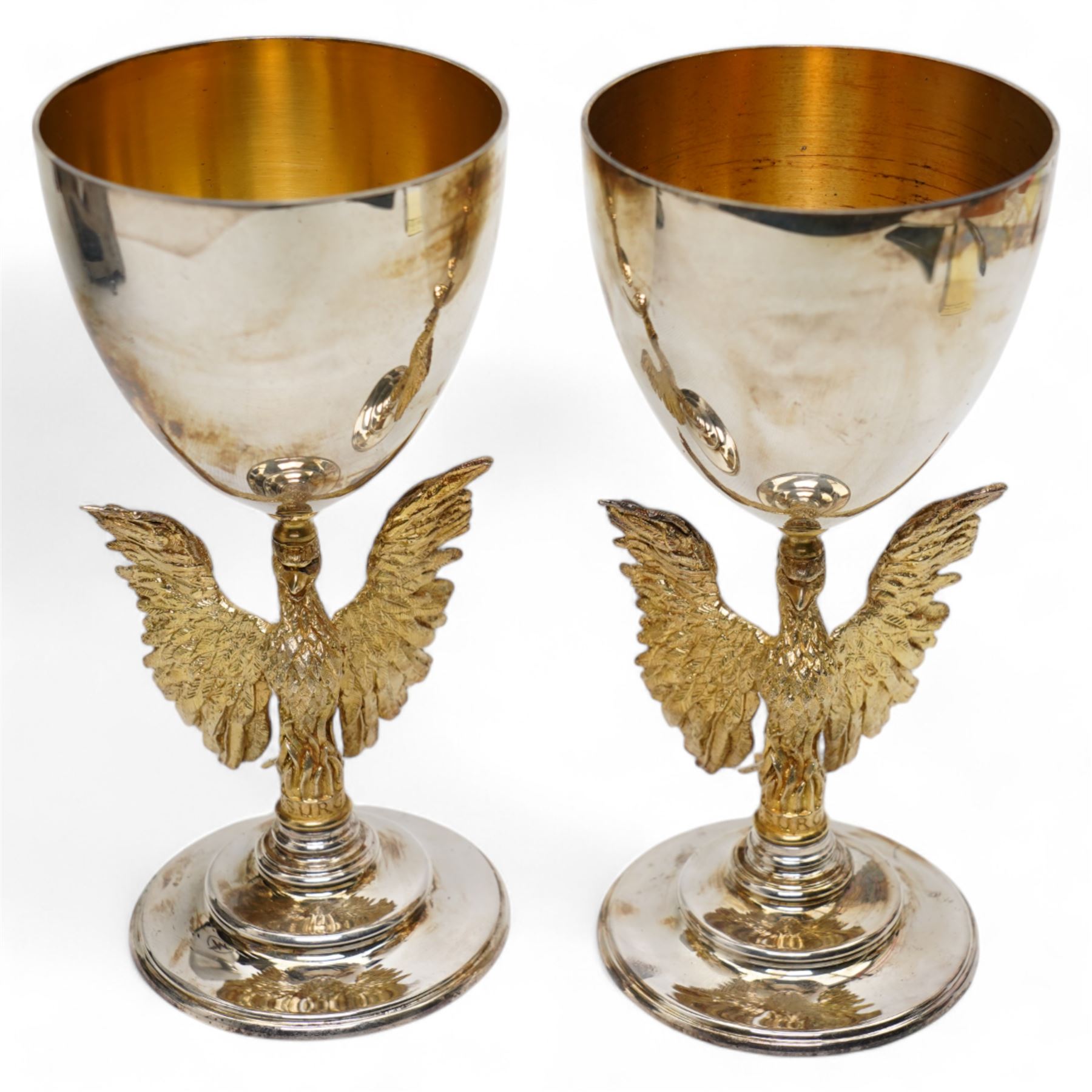 St Paul's Cathedral limited edition silver goblets, commemorating the 300th anniversary of the laying of the foundation stone of the cathedral in 1675, designed by Jocelyn Burton for Aurum, the gilt stems sculpted as phoenixes with outstretched wings supporting the bowl, the pedestals inscribed 'Resurgam', with gilded interiors, no. 188 and 189/600, hallmarked Jocelyn Burton, London 1975, H16cm, with certificates and original case