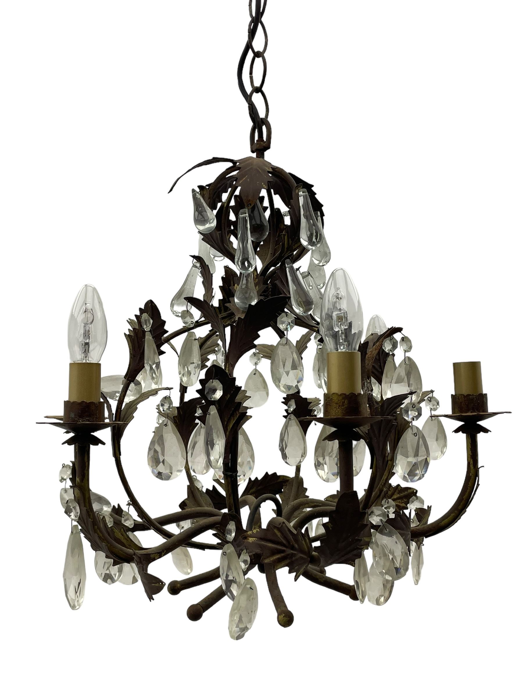 Early 20th century wrought metal chandelier, of scrolled form with six branches, decorated with leafage and glass pendants 