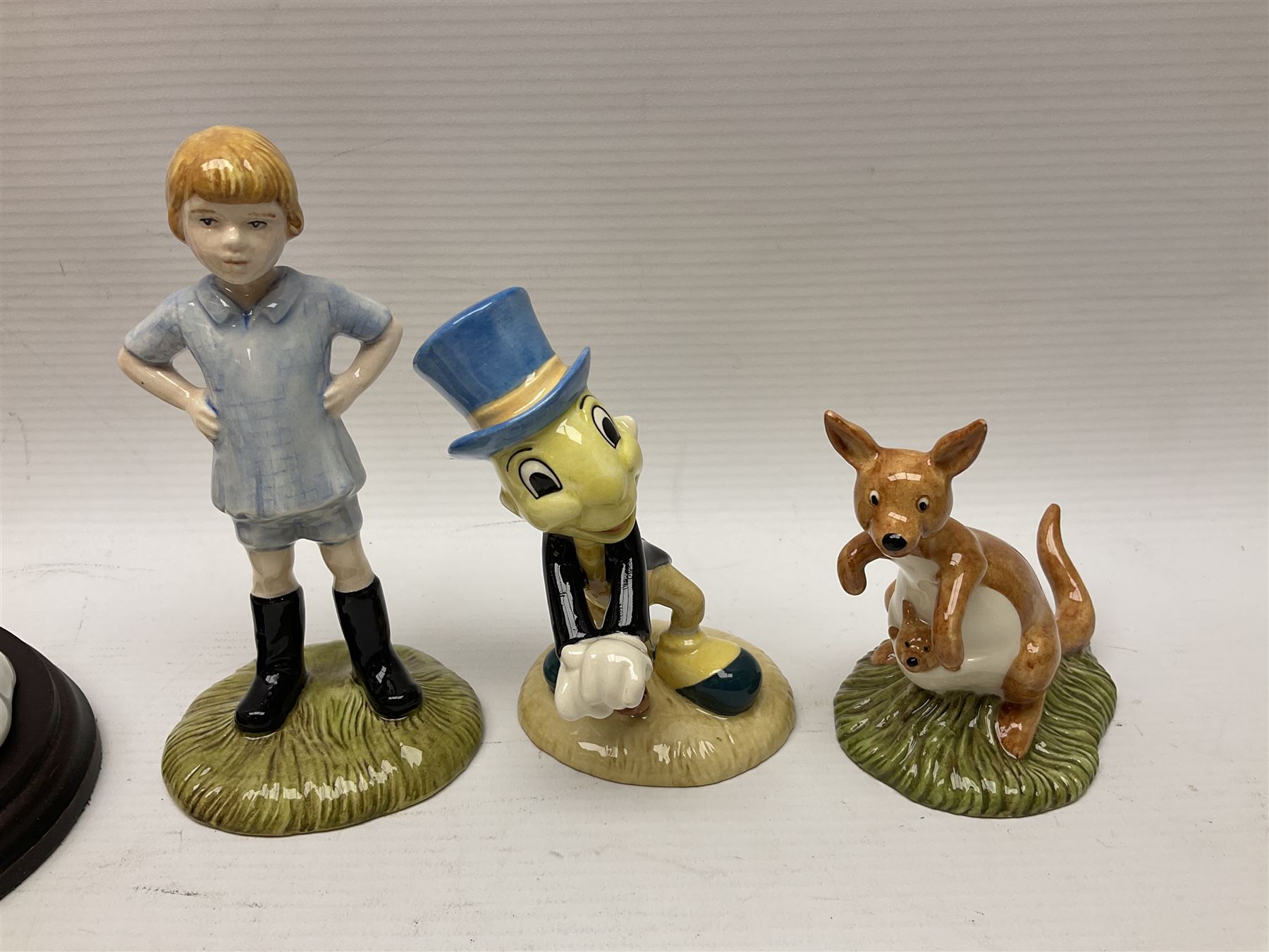 Nine Royal Doulton Winnie the Pooh Collection figures, including Oh Dear Bath Time's Here, Going Sledging, Tigger's Splash Time and Christopher Robin, together with a Royal Doulton Disney Showcase Jiminy Cricket figure, all boxed