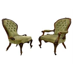 Pair of lady's and gentleman's Victorian carved walnut armchair and nursing chair, foliate carved cresting rail over shaped back with scrolled acanthus carved sides, the armchair with scroll arm terminals, the spoon back and sprung seat upholstered in buttoned sage green velvet, raised on cabriole supports with bell-flower moulded knees and scroll feet, on ceramic castors