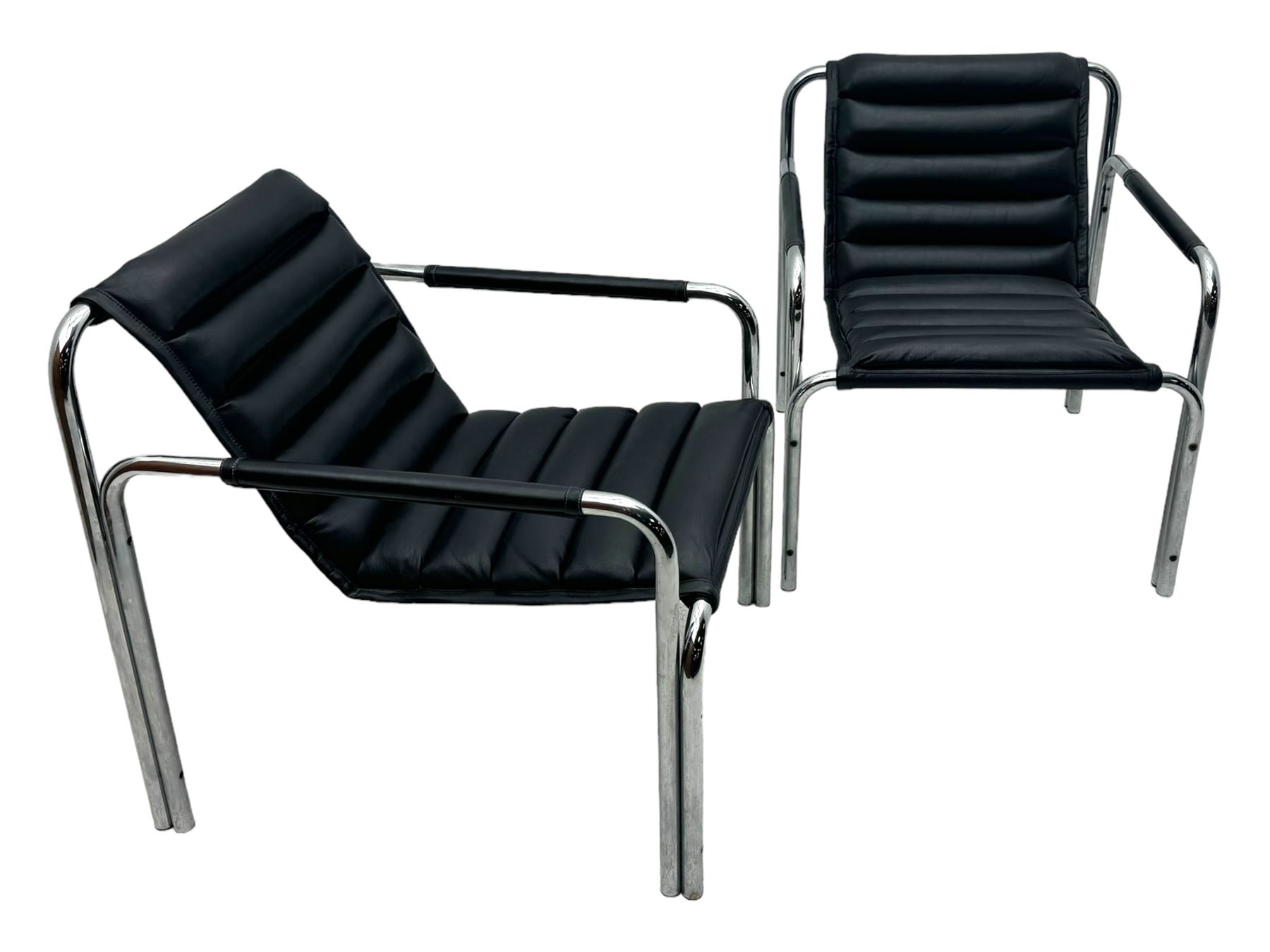 Baroumand Designs - pair of mid 20th century modernist armchairs, slung black leather seat with horizontal channel tufting, tubular chrome frame with curved arms, raised on tubular supports