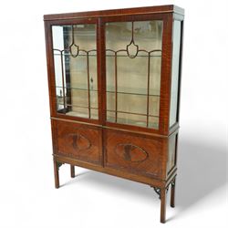 Early 20th century mahogany display cabinet, enclosed by astragal glazed doors over two scalloped panelled cupboard doors, on square supports with pierced scrolling brackets