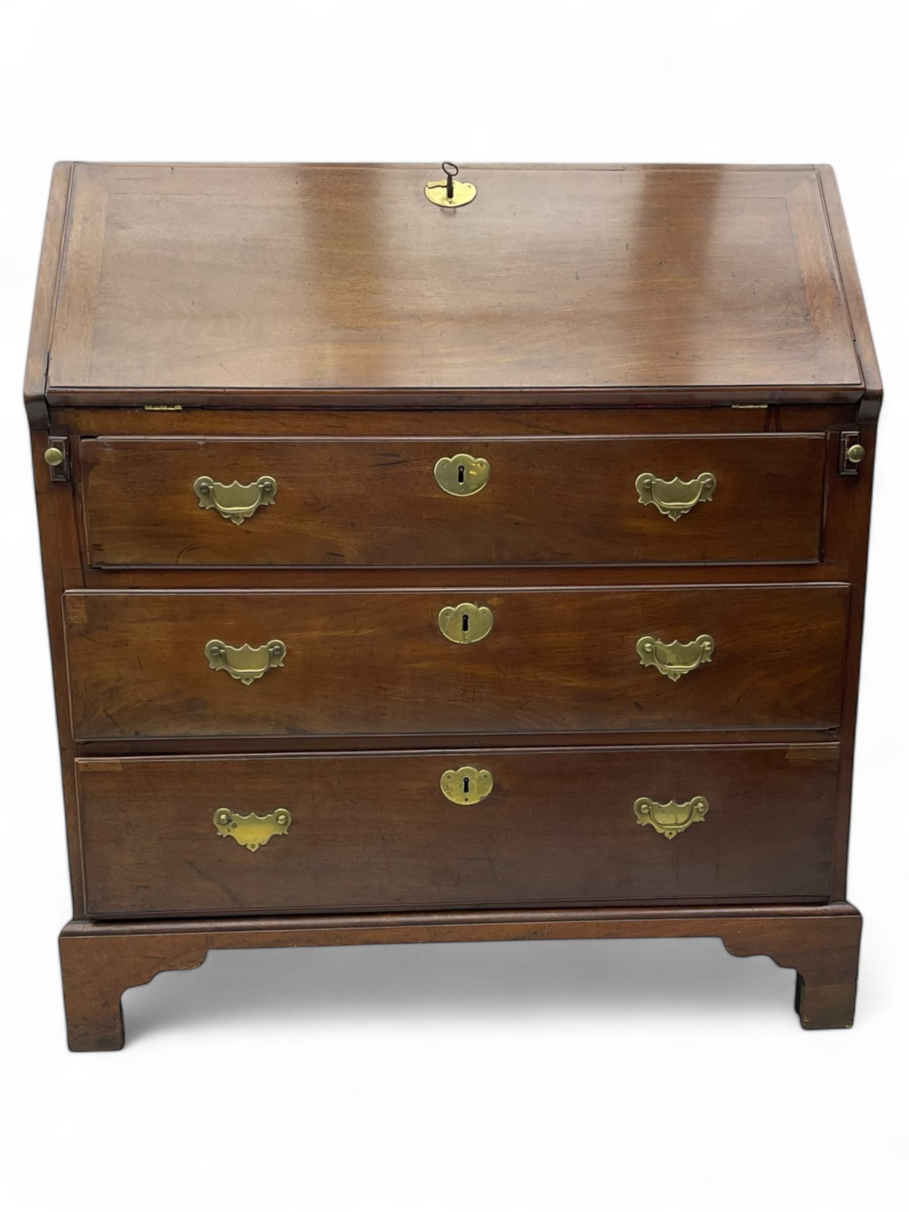 George III mahogany bureau, the fall front enclosing fitted interior, three graduating long drawers, on bracket feet