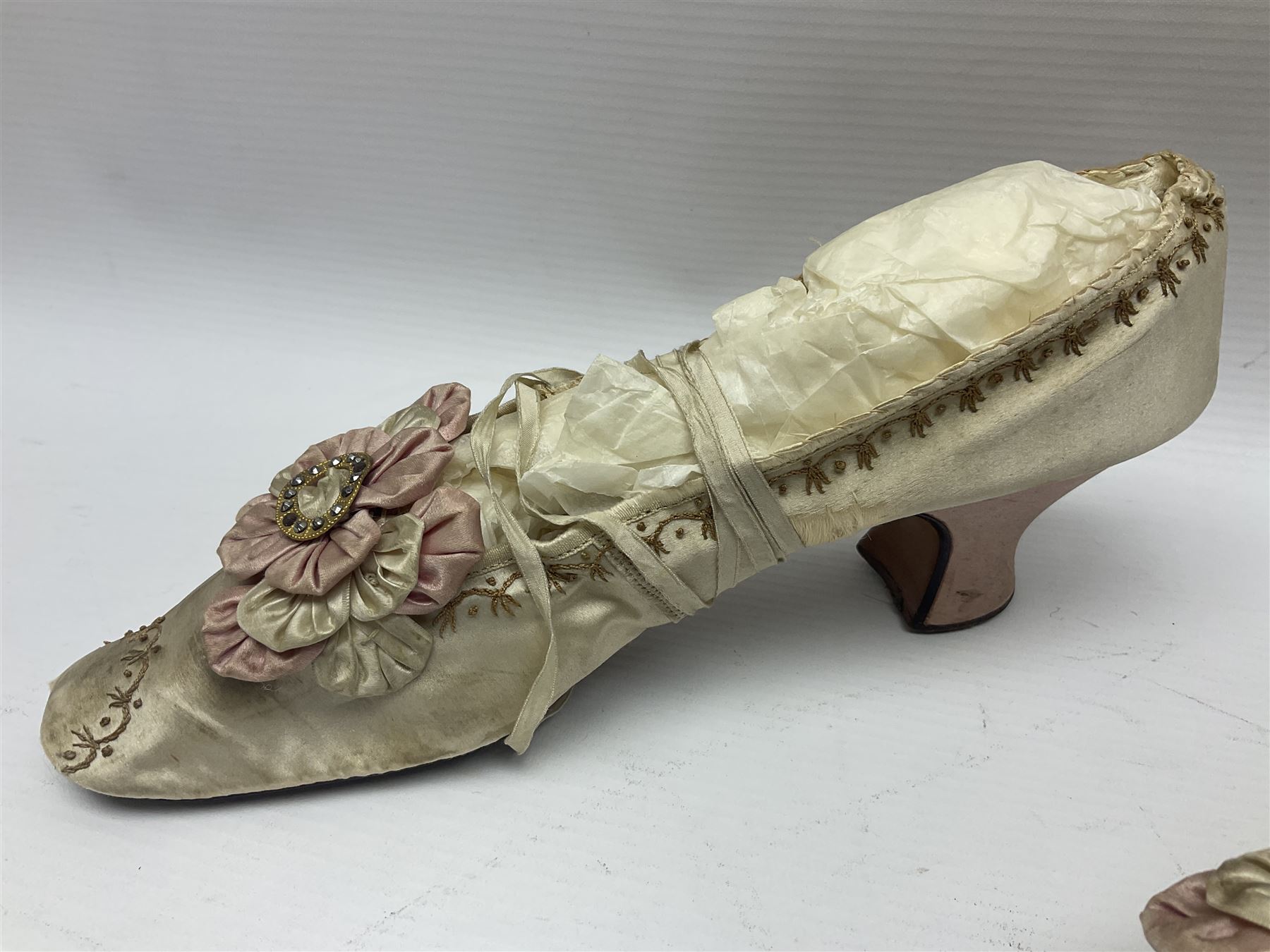 Pair of 19th century ivory silk satin ladies shoes, with rosette to the vamp, with pink silk satin heel, L23cm