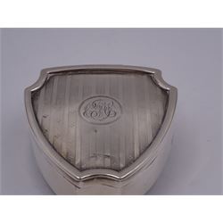 Early 20th century silver mounted trinket box, of shield form, with engine turned decoration and engraved circular cartouche to hinged cover, opening to reveal green velvet interior, upon three pad feet, hallmarked Walker & Hall, Sheffield 1914, H3.5cm, W7cm