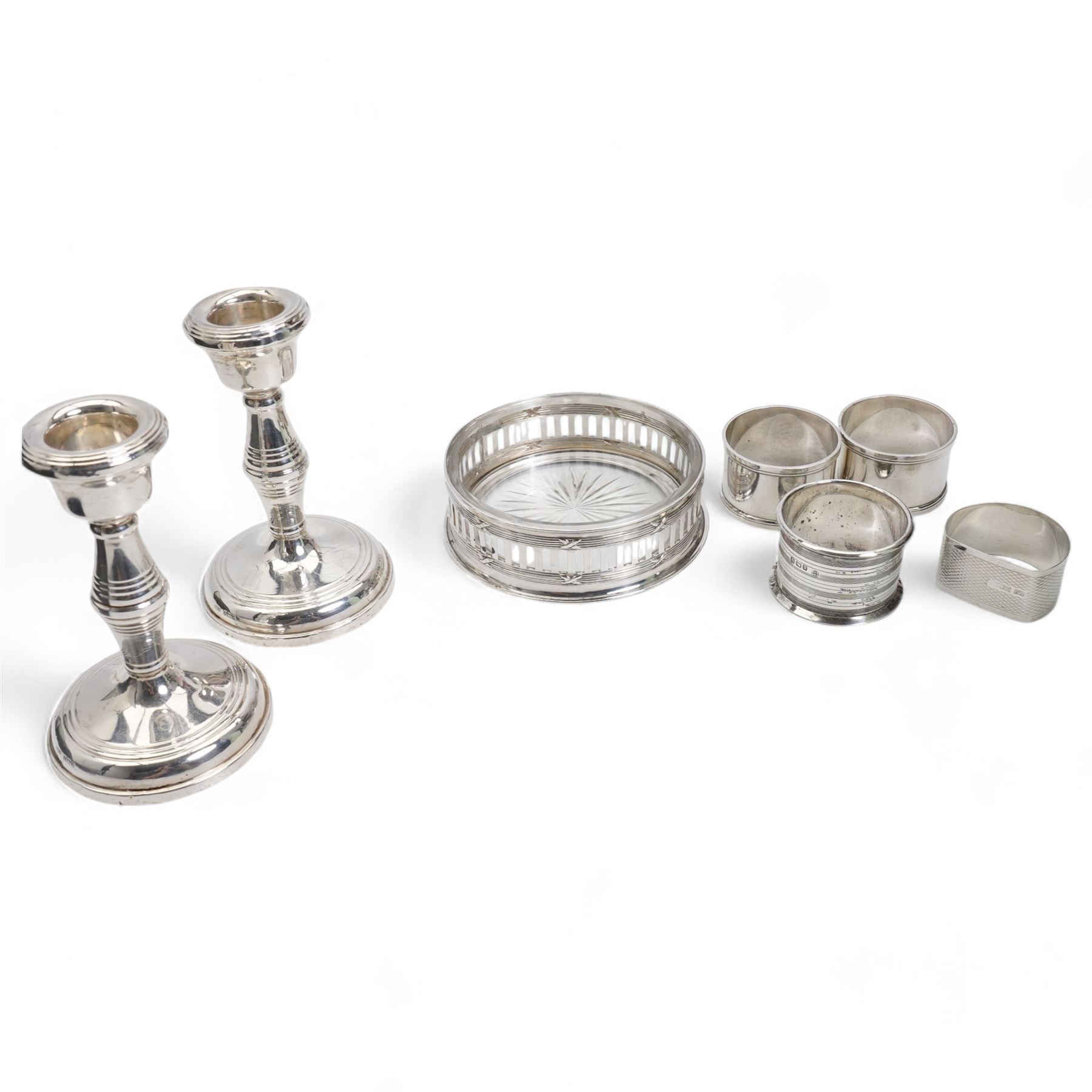 Pair of silver dressing table candlesticks H11cm Birmingham 1959, four various silver serviette rings and a glass and silver coaster