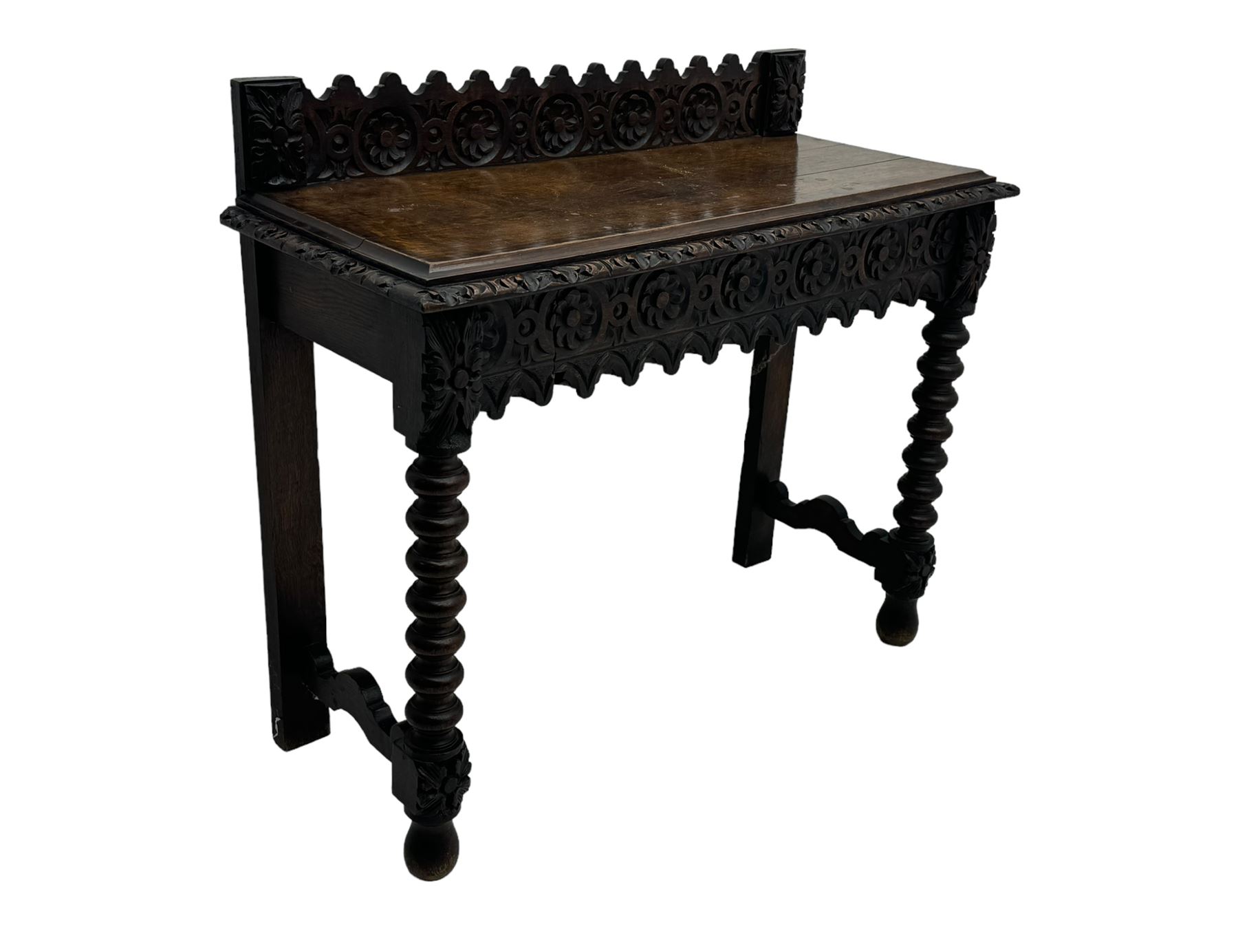 Victorian Gothic revival style carved oak console table, rectangular top with carved edge and raised back gallery, over deeply carved apron with floral and foliate motifs and central drawer, barley twist front supports and plain rear supports united by shaped stretchers, on front bun feet