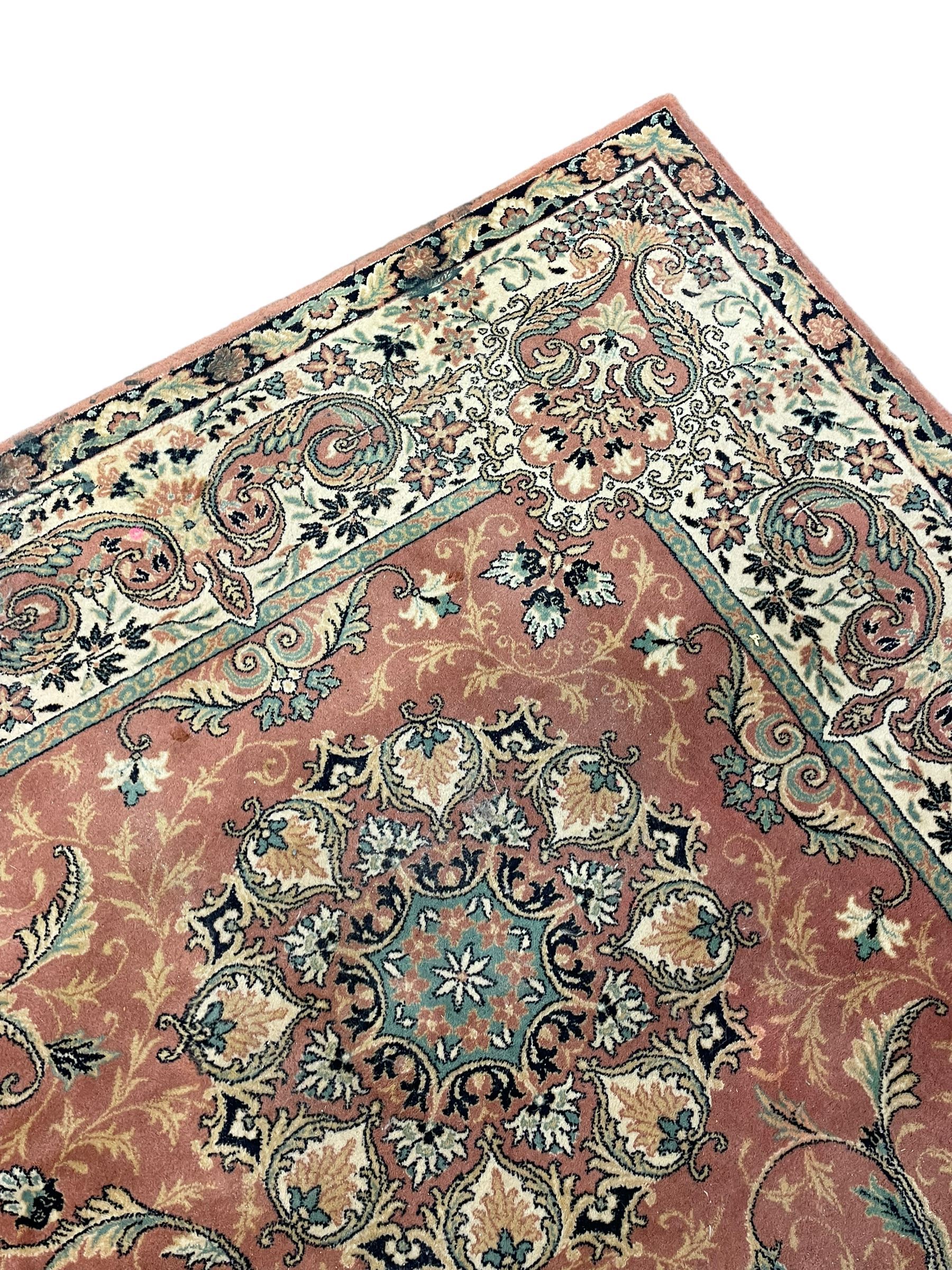 Persian design peach ground carpet, central floral medallion surrounded by scrolling foliage, decorated all over with stylised plant motifs, floral design repeating border