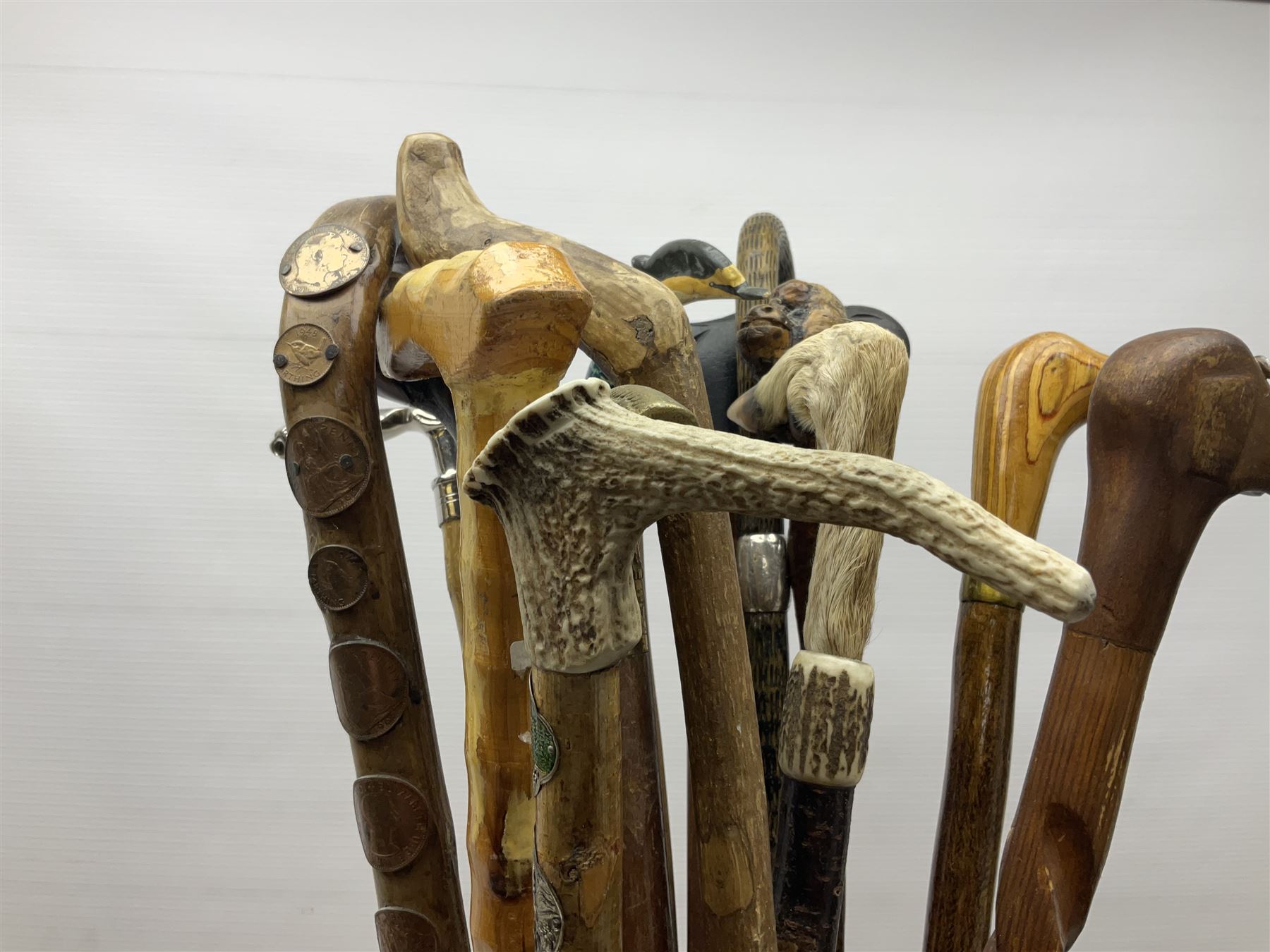 Oak barley twist stick stand, with a collection of walking sticks including examples with carved pommels, horn handles, silver collar etc, together with brass stick stand 