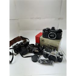 Four Canon SLR camera bodies, to include AE-1 Program, in black and silver finish, serial no. 4330401, boxed, AE-1 serial no. 1234206 and two AV-1 examples, serial nos. 841957 & 334882, one with a Canon FD 50mm 1:18 lens