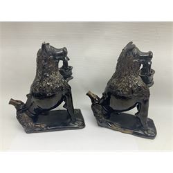 Pair of unusual early English pottery figures, modelled in the form of seated dogs with baskets between their jaws, the tails forming whistles, each upon rectangular base, overall H22cm