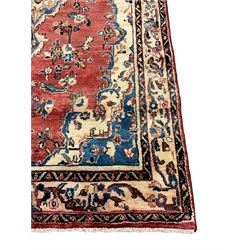 Persian Mahal red ground rug, central floral design pole medallion on a field decorated with flowerheads and foliage, the border decorated with trailing leafy branch and flowerheads 