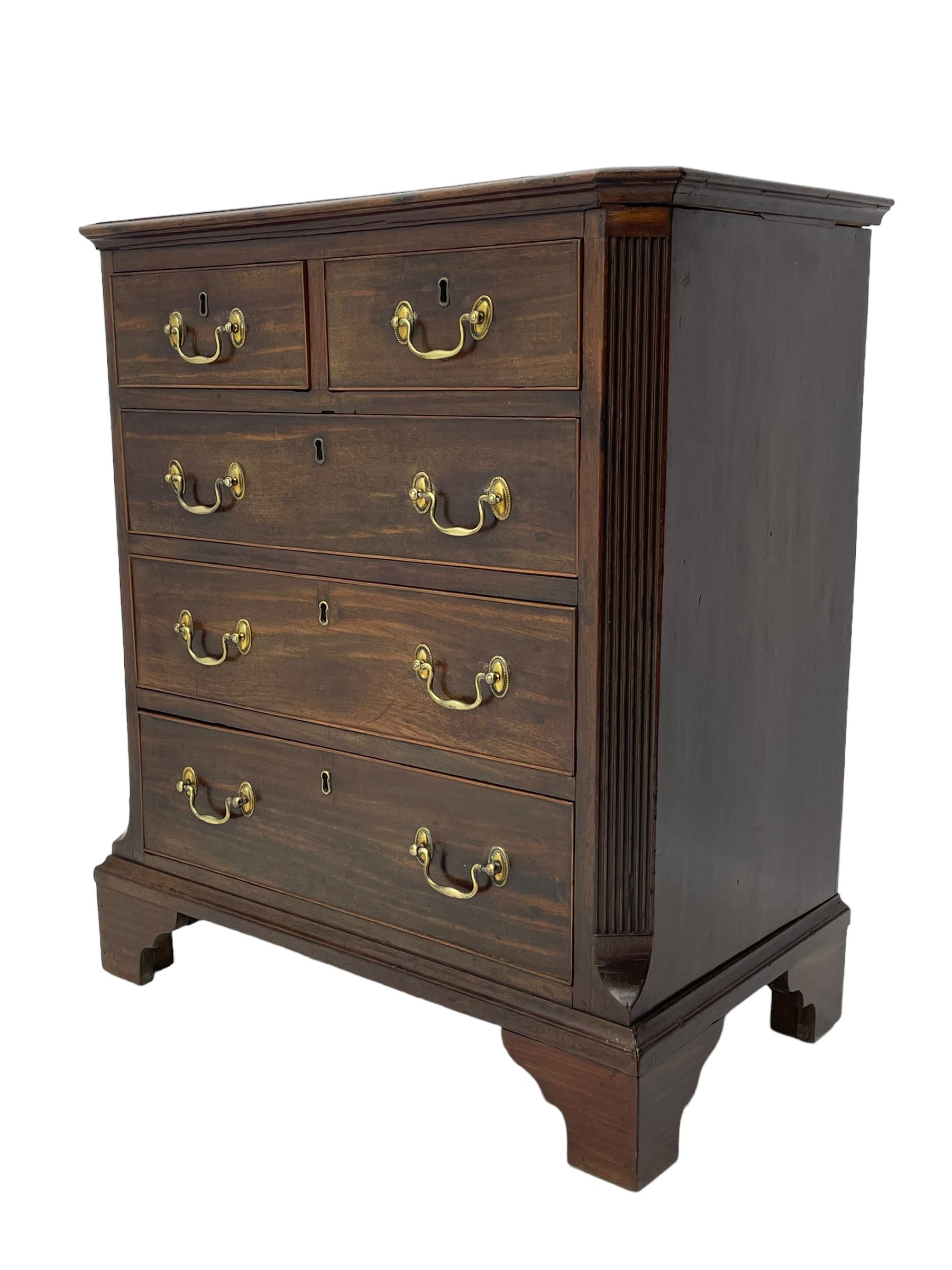 Small George III mahogany chest, rectangular canted form, moulded top over two short and three long cock-beaded drawers, fitted with brass swan neck handles and oval plates, enclosed by fluted upright corners, on bracket feet 