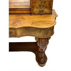 19th century figured walnut dressing table, the raised bevelled mirror back in carved foliage frame with scrolled terminals, fitted with central hinged compartment flanked by small trinket drawers, serpentine moulded top over single frieze drawer, on cabriole supports united by a platform base