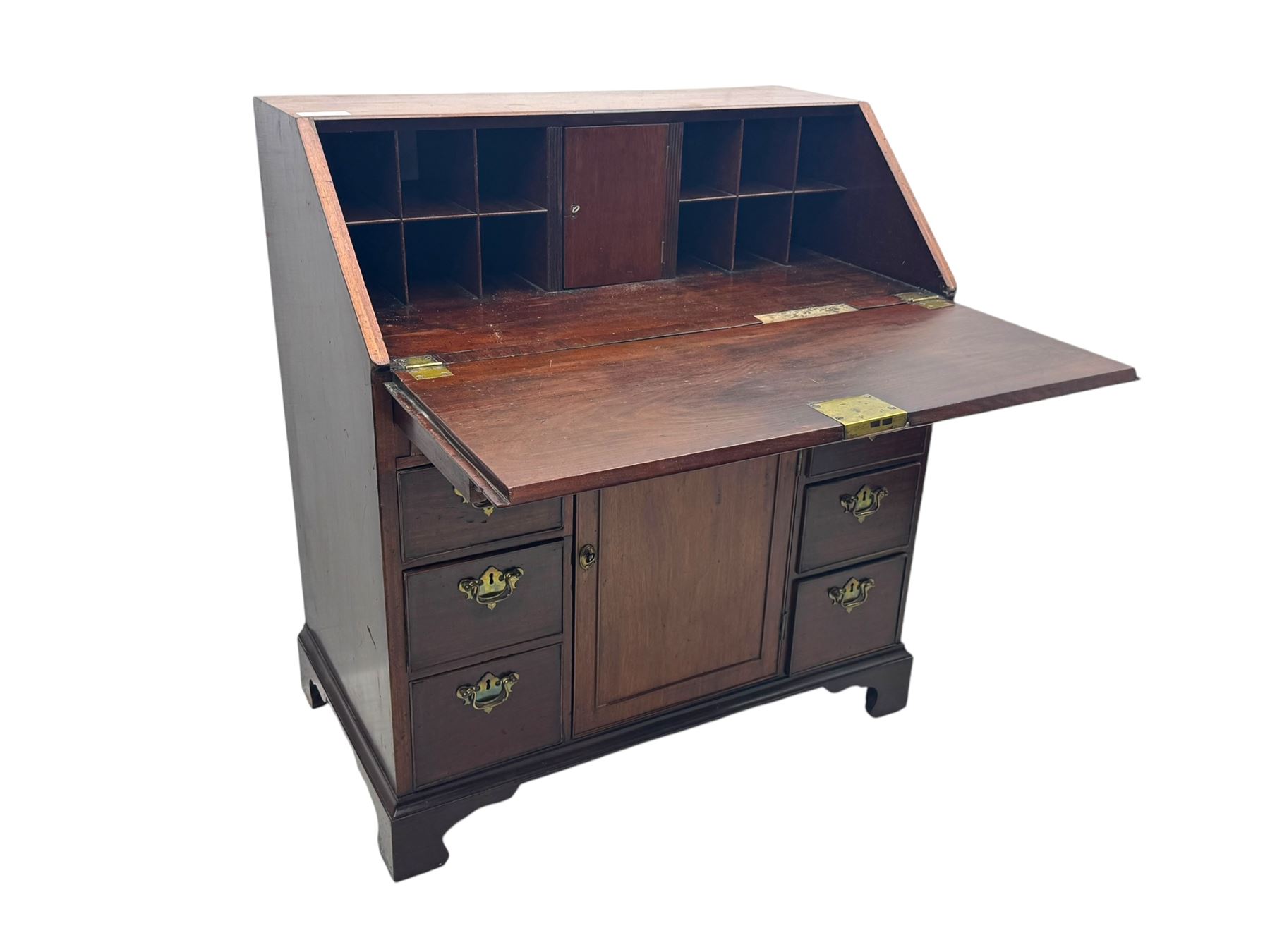 George III mahogany bureau, the fall-front enclosing fitted interior with pigeonholes and central cupboard, over an arrangement of nine short drawers surrounding a central cupboard, on shaped bracket feet