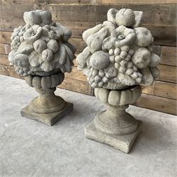 Pair of cast stone garden wall or gate finials depicting Fruit Piers, raised on separate circular squat column with plinth base