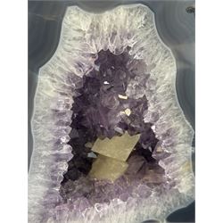 Amethyst crystal ‘cathedral’ geode, free standing with flat base and prepared outer surface, with well-defined crystals of various sizes within the cavern, H25cm, W25cm