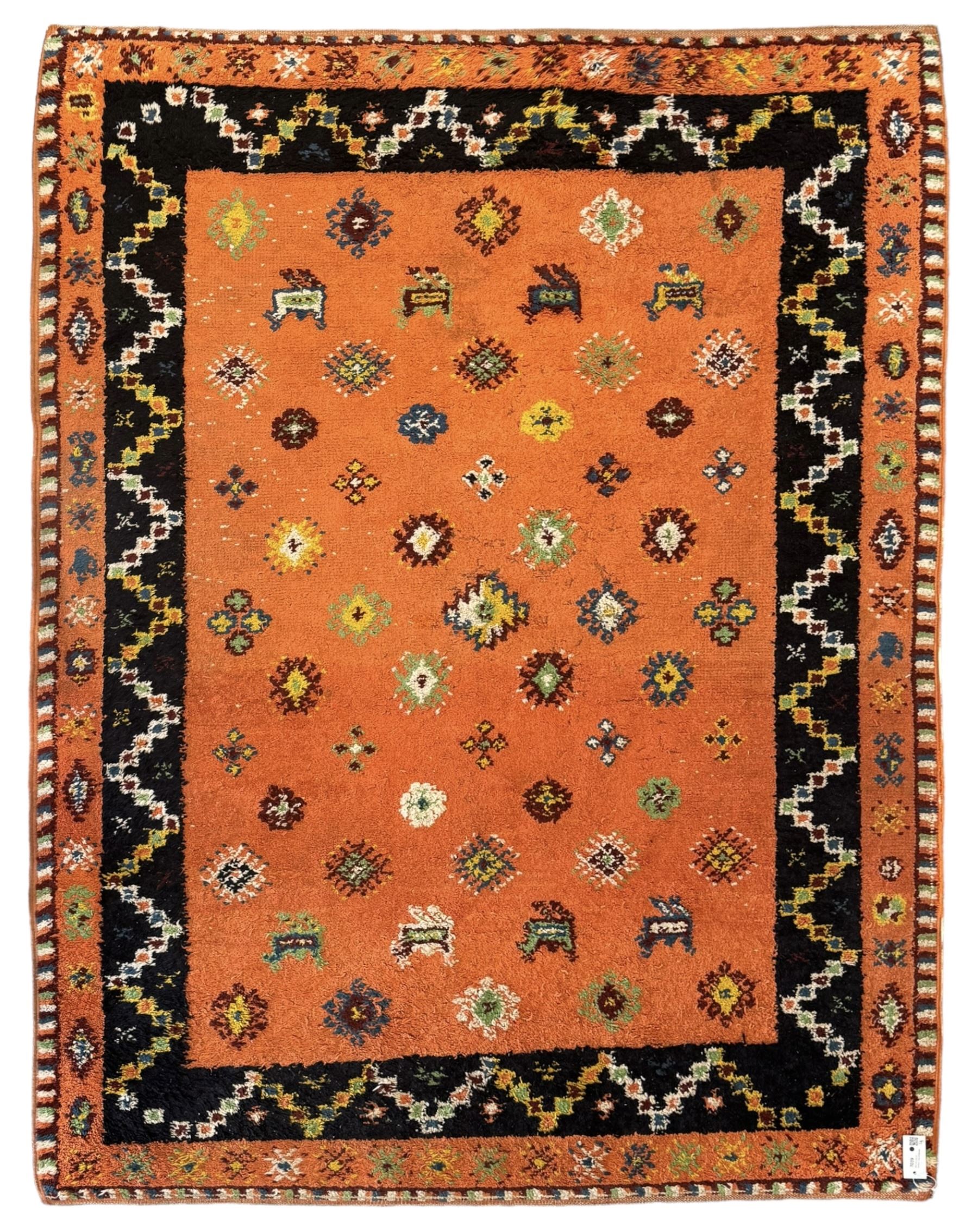 Moroccan amber ground thick pile rug, the field decorated with stylised geometric lozenges and camel motifs, the guard bands with stylised foliate and plant motifs