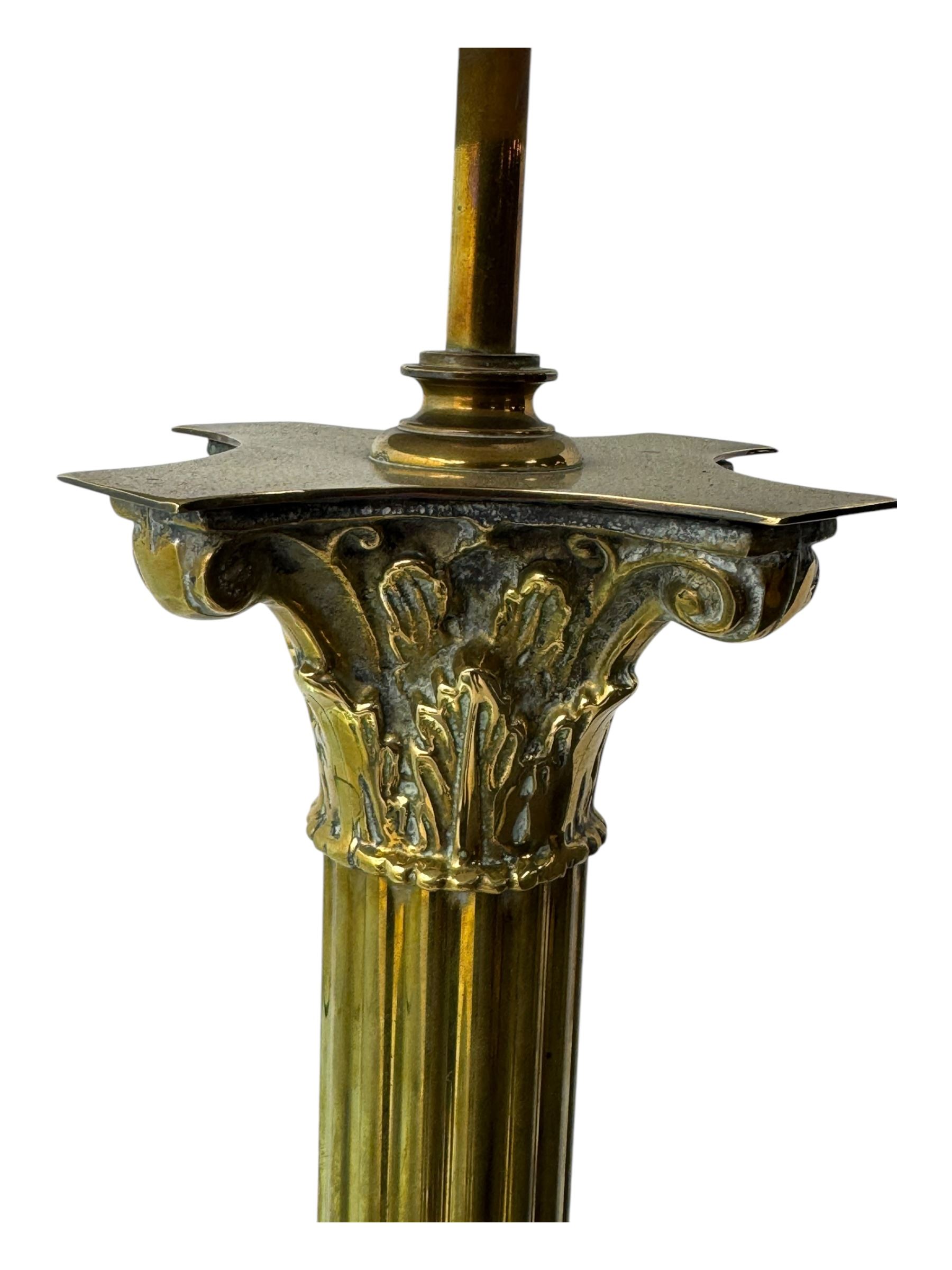 20th century brass standard lamp, Corinthian column stem on moulded square base with paw feet 