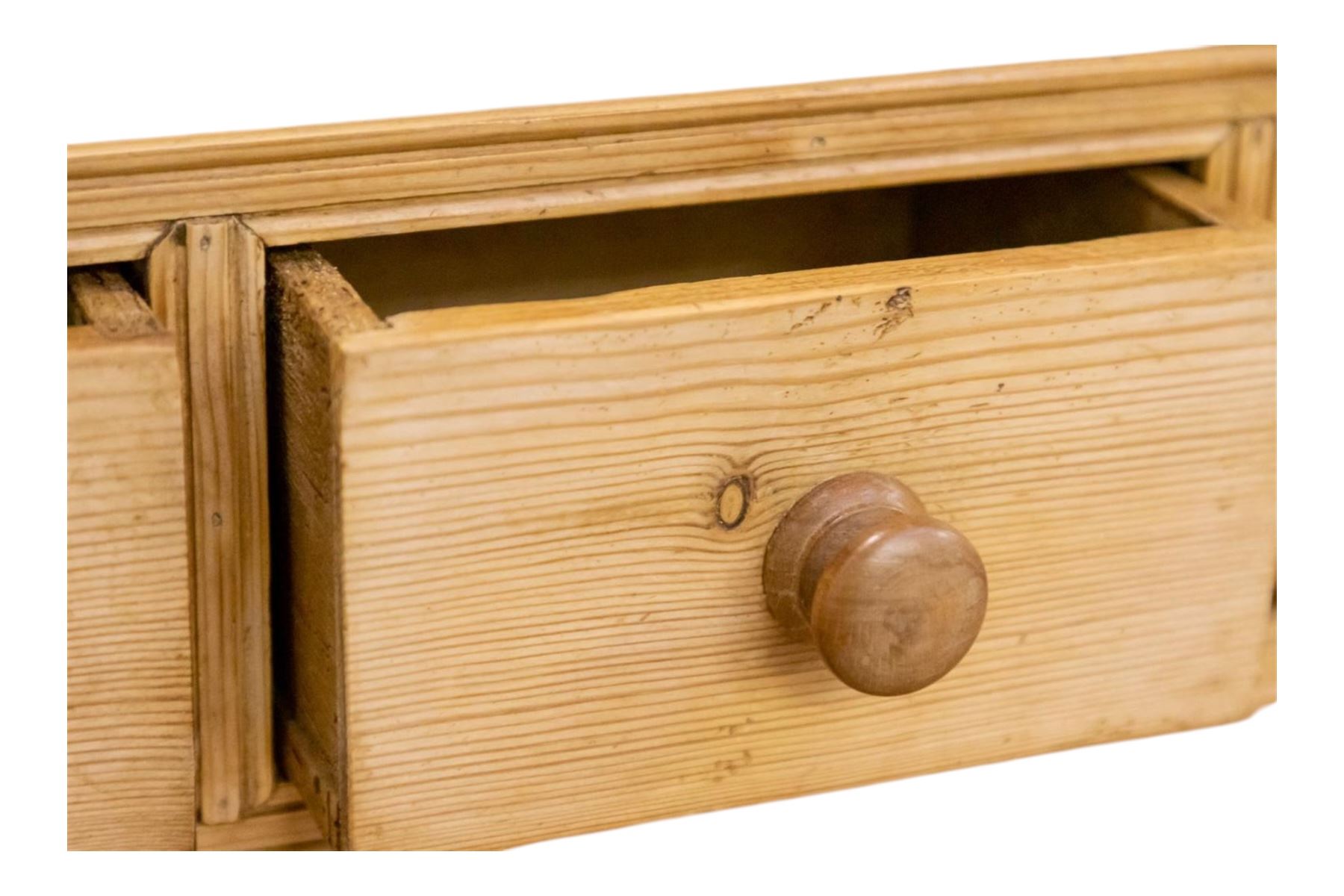 Early to mid-19th century pine cottage dresser, projecting cornice over fretwork frieze, the rack fitted with two shelves over a bank of seven small spice drawers, the base comprising two drawers above an open shelved section