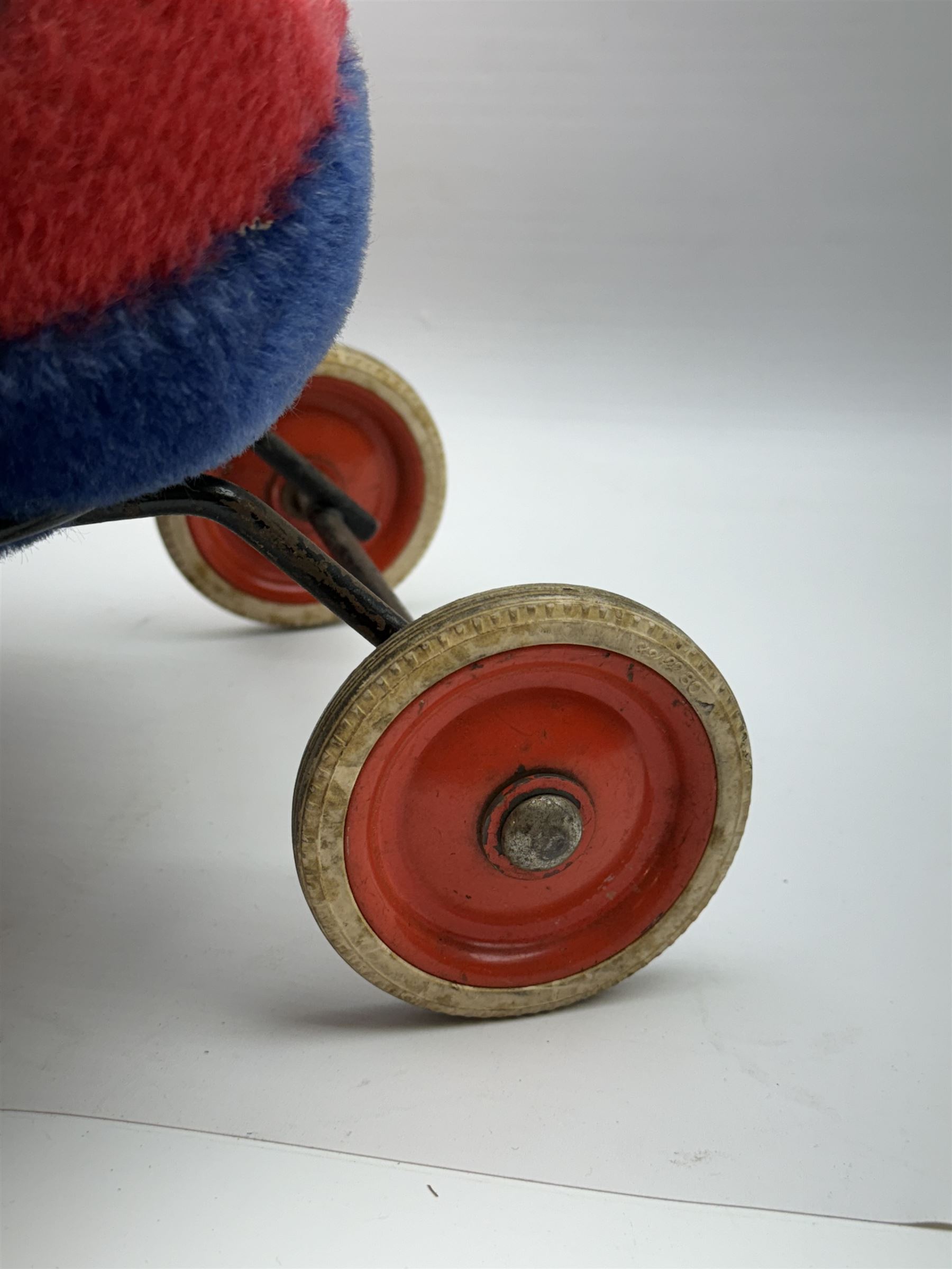 Steiff child's ride on ladybird, circa 1950s, the mohair body with red and black spotted seat, black and white face and blue underbelly, upon a metal frame with rubber and metal wheels, H30cm, W52cm