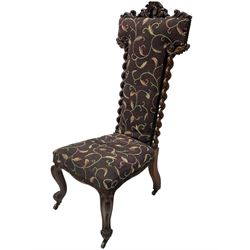 Victorian walnut prie-dieu chair, cresting rail carved with cartouche and extending scrolling foliage, back flanked by spiral turned column uprights, upholstered in foliate patterned fabric, raised on cabriole supports with scroll feet and castors