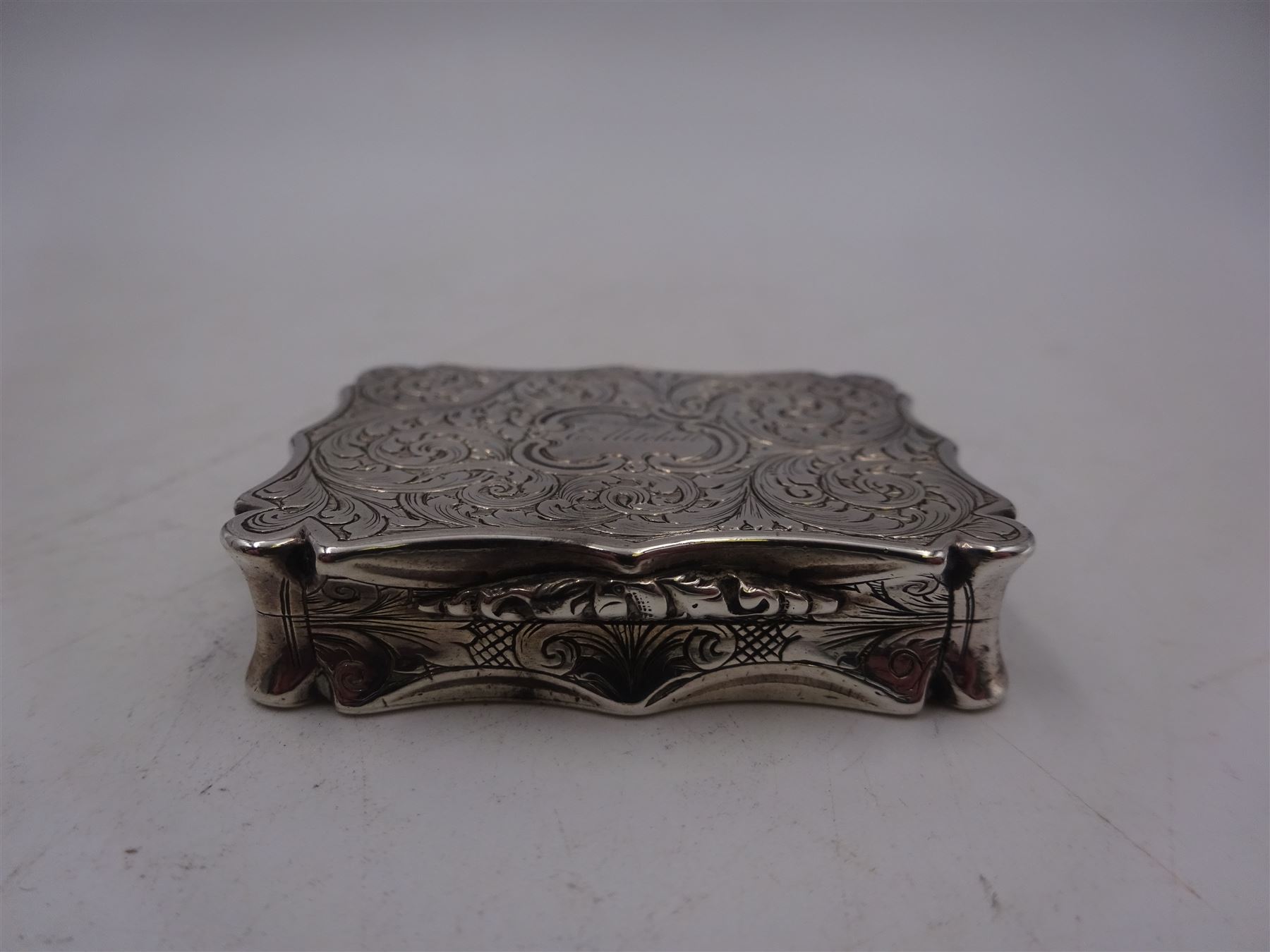 Victorian silver vinaigrette, with bright cut scrolling decoration and engraved name to hinged cover, the gilt interior with typical pierced cover, hallmarked Nathaniel Mills, Birmingham 1848, W4.2cm