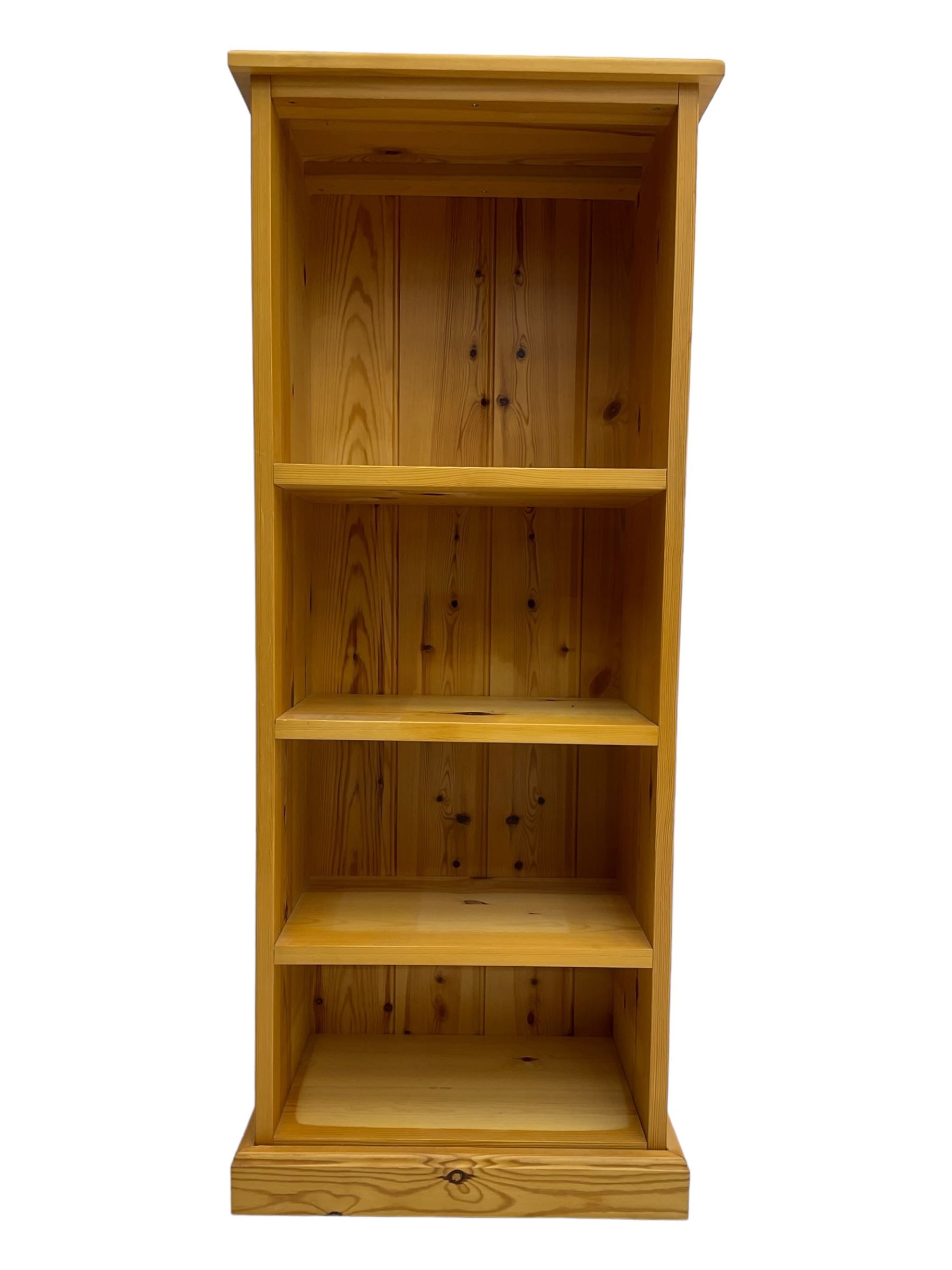 Narrow pine open bookcase, rectangular top over three shelves, on plinth base