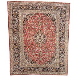 Persian Kashan crimson ground carpet, floral design central medallion surrounded by trailing leafy branches and stylised plant motifs, multi-band border with repeating floral design