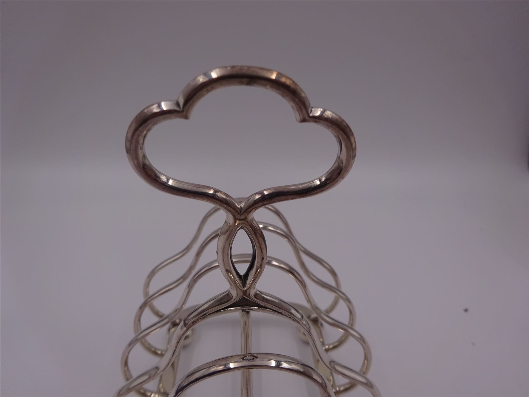 Victorian silver seven bar toast rack, each bar of trilobed form, with similar loop handle and upon four bun feet, hallmarked John Gilbert, Birmingham 1863, H16.5cm