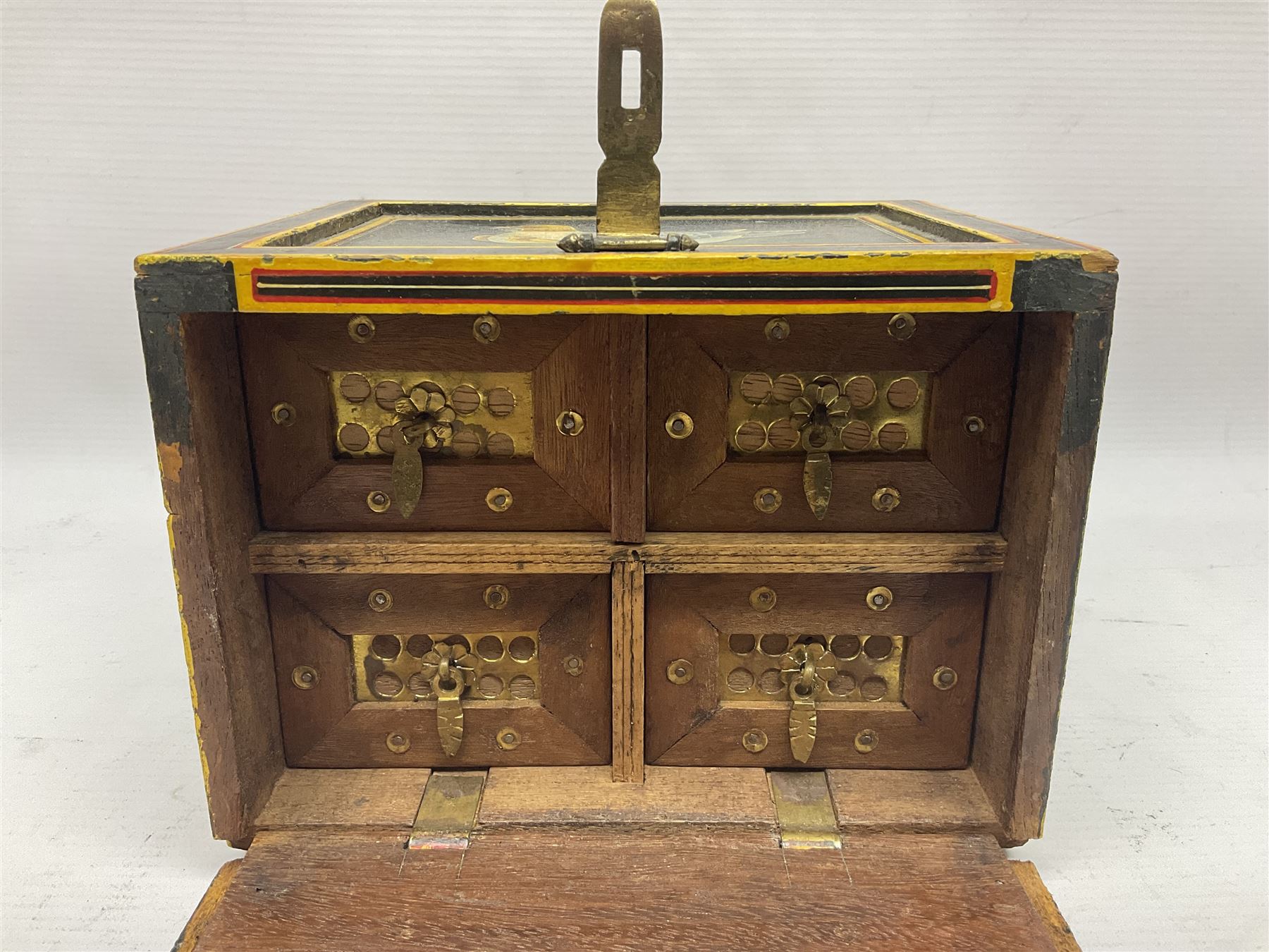 Small wooden collectors chest, painted to each side with birds upon a black ground within red and yellow borders, opening to reveal a compartmentalised interior containing one long drawer above two smaller drawers, H13cm, W18cm, D14.5cm