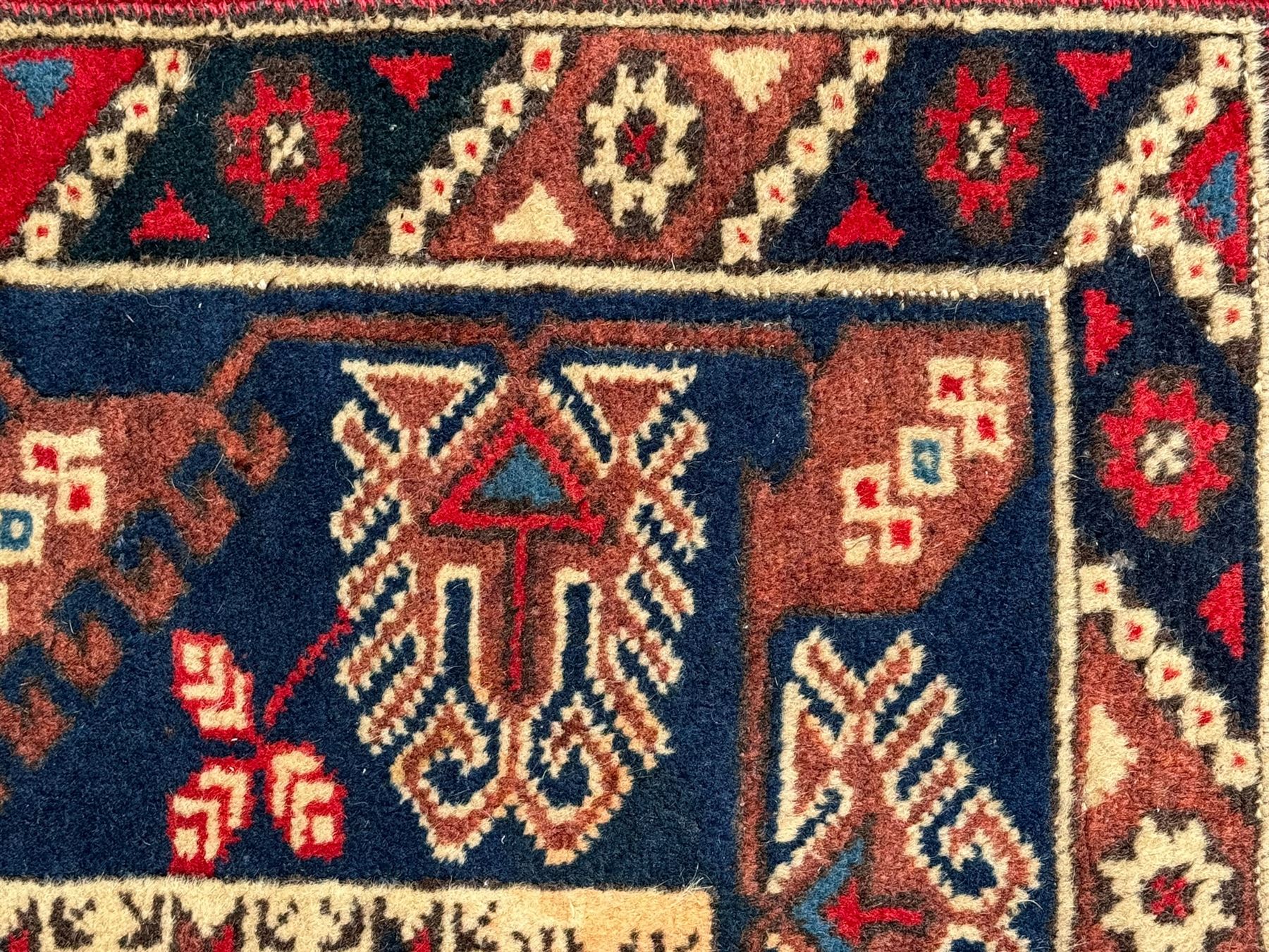 Turkish crimson ground rug, the field decorated with three geometric medallions within a band of star motifs, the main border decorated with stylised plant motifs 