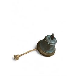 Late 19th century/early 20th century bell with rope pull, probably a fire bell, marked LCC G49 to canon, upon a black painted wrought iron wall mount, bell H29cm, mount H64cm