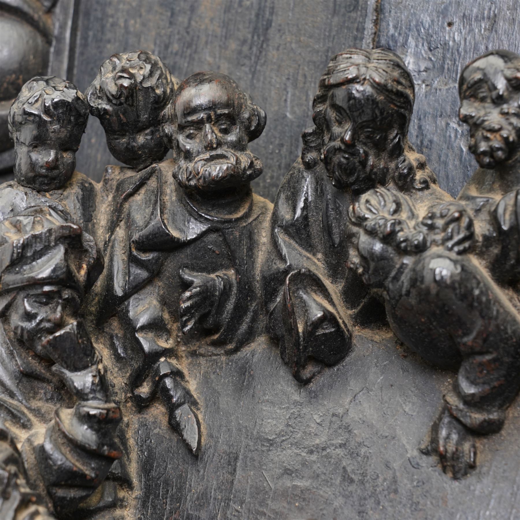 Late 17th century South German or Flemish carved oak figural group depicting 'The Last Supper', comprised of twelve figures facing each other around a central table, standing on on a later oak panel, the frieze carved with a central female mask flanked by foliate carvings, the group presented under an egg-and-dart carved arch, the base decorated with a protruding cartouche, flanked by cherub masks