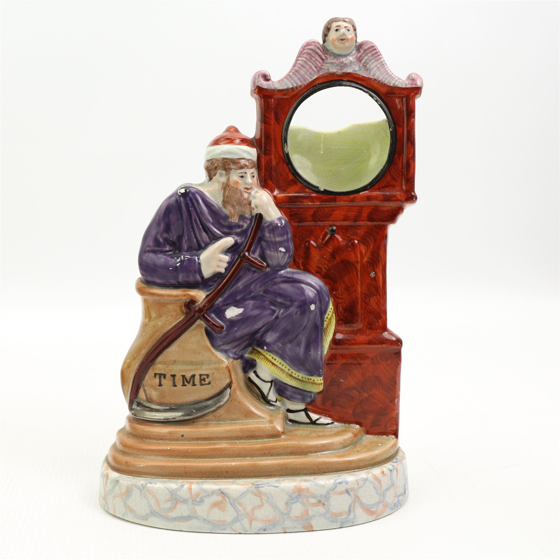 Victorian Staffordshire pocket watch stand, modelled as the Chronos, seated beside a grandfather clock, on oval marbled base, H23cm together with a 19th century oval brass snuff box engraved with Shrewsbury Castle, L13cm (2)