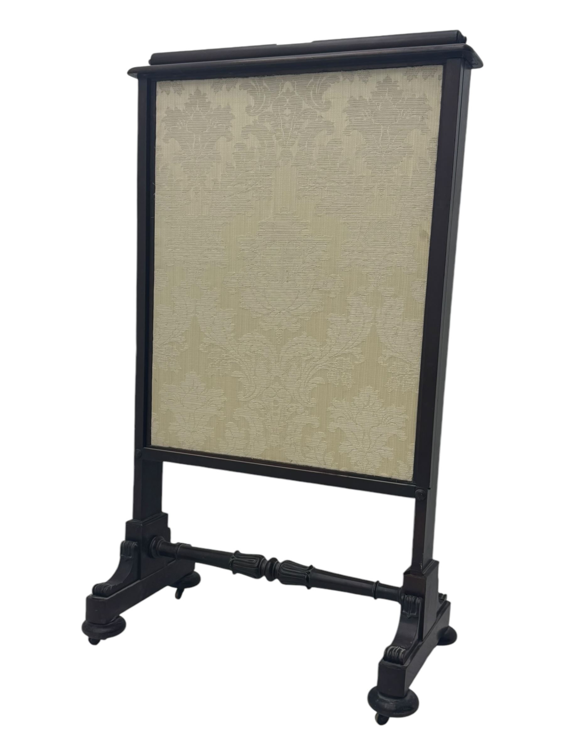 Early 19th century mahogany fire screen, upholstered in cream foliate pattern fabric, pull-up panel and sliding panel, raised on platforms united by turned and lappet carved stretcher, on compressed bun feet with castors 