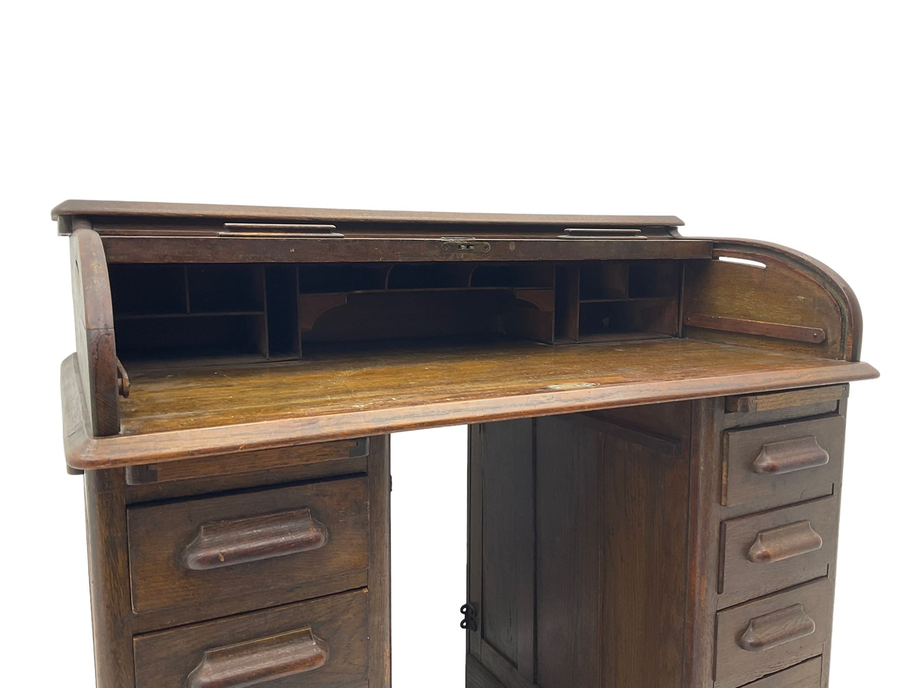 Early 20th century oak twin pedestal roll top desk, tambour roll enclosing fitted interior, each pedestal fitted with four drawers and slide, on plinth base 