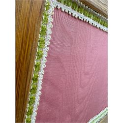 Edwardian oak and fabric folding screen, featuring three panels with oak frames, one side covered in green striped fabric with decorative trim, the reverse side in pink moiré effect fabric, connected by brass hinges