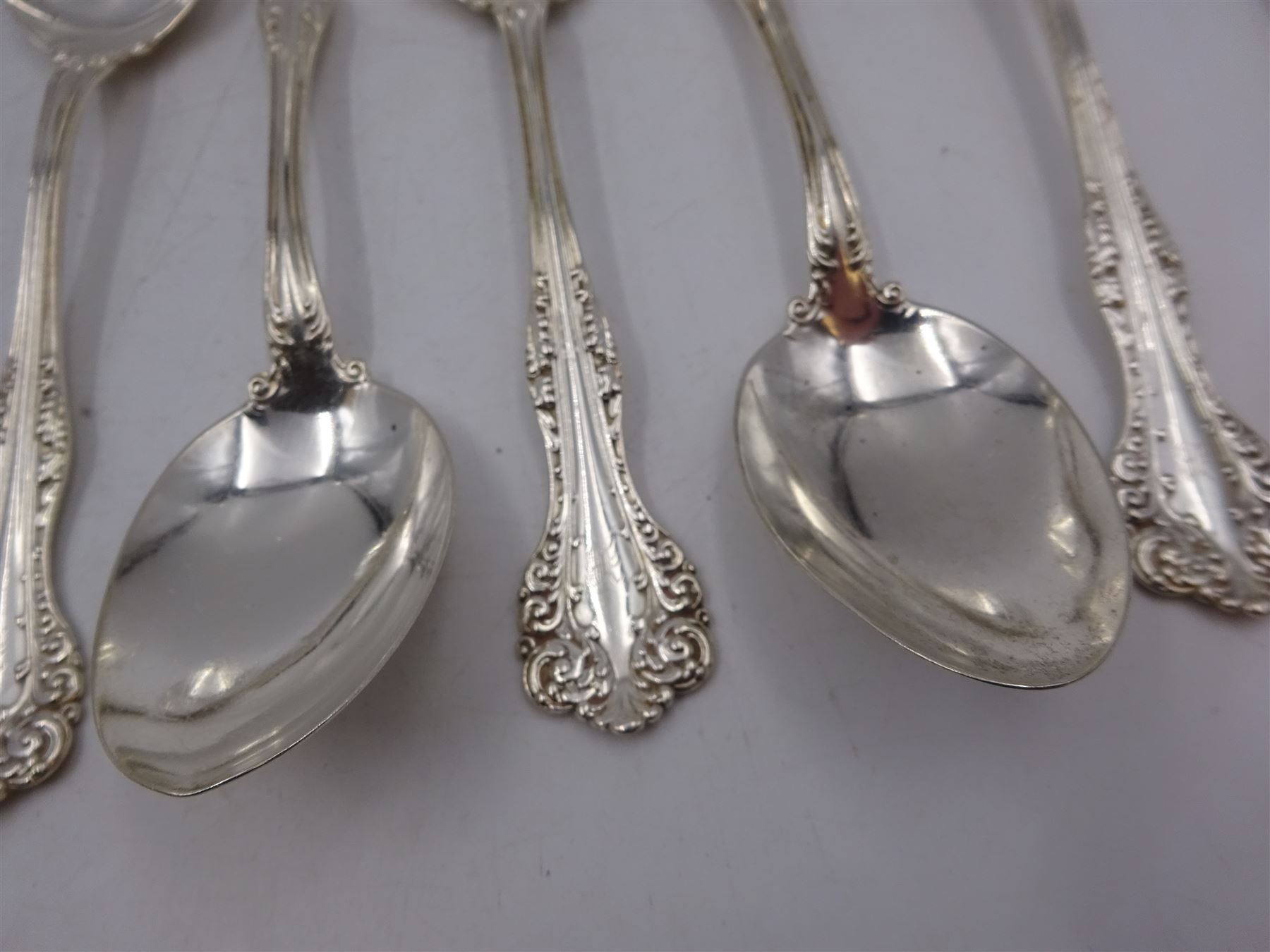 Group of American silver flatware, comprising set of three table spoons, each with beaded stem and engraved with initialsm marked for Mermod & Jaccard Jewelery Co. and a set of six American silver dessert spoons, each engraved with initial in a scrolling border, stamped Sterling