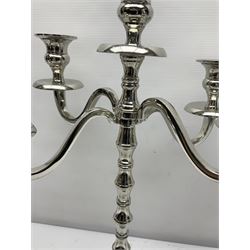 Pair of four branch candelabra, urn-shaped nozzles raised upon scroll branches supported from tapering central stem, with a stepped circular base, with another similar, pair H40cm
