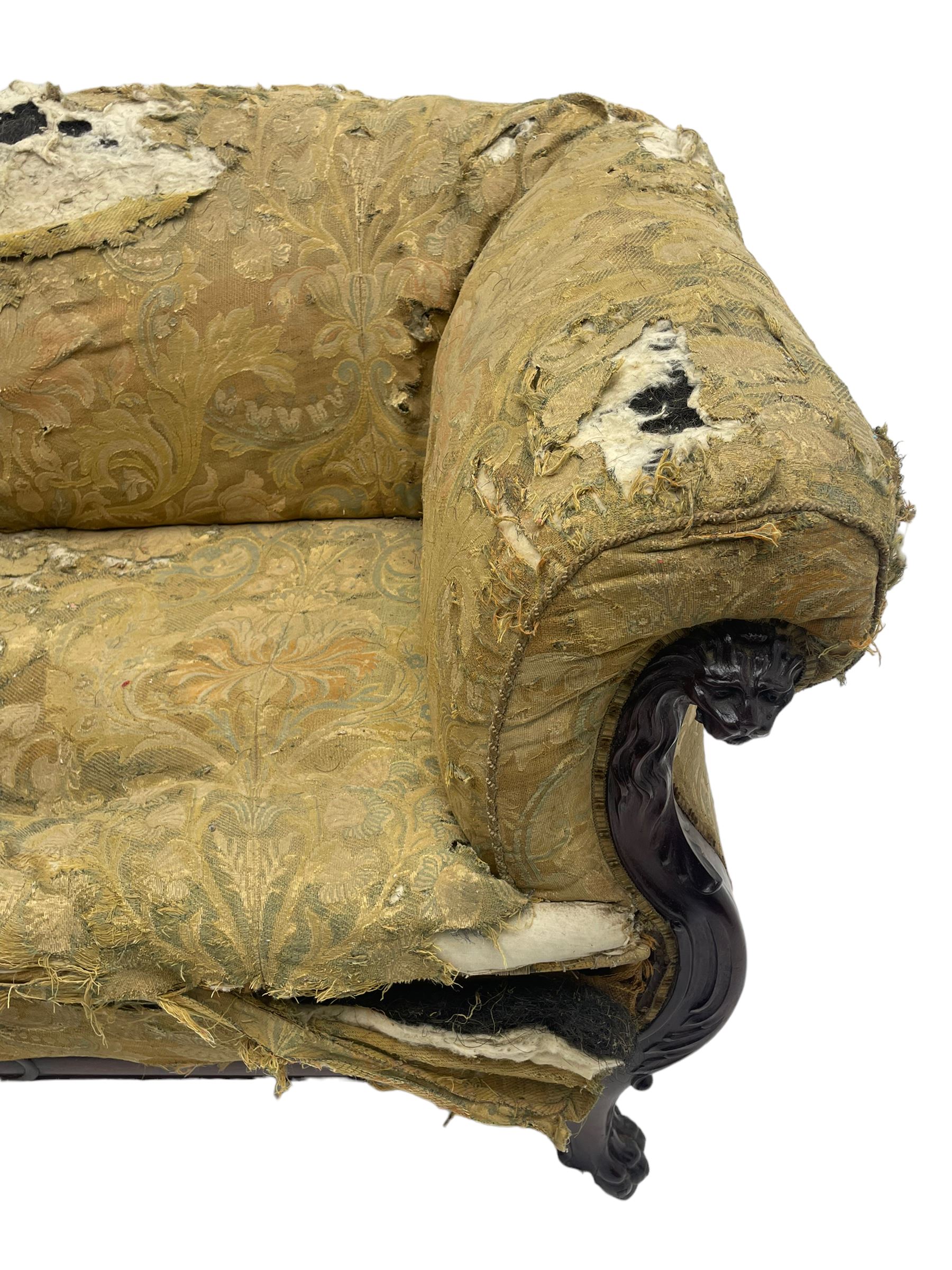 19th century mahogany settee, rolled S-scrolled arms carved with lion masks and acanthus leaf scrolls, the lower moulded rail carved with scrolling design, raised on carved paw feet with recessed brass and ceramic castors 