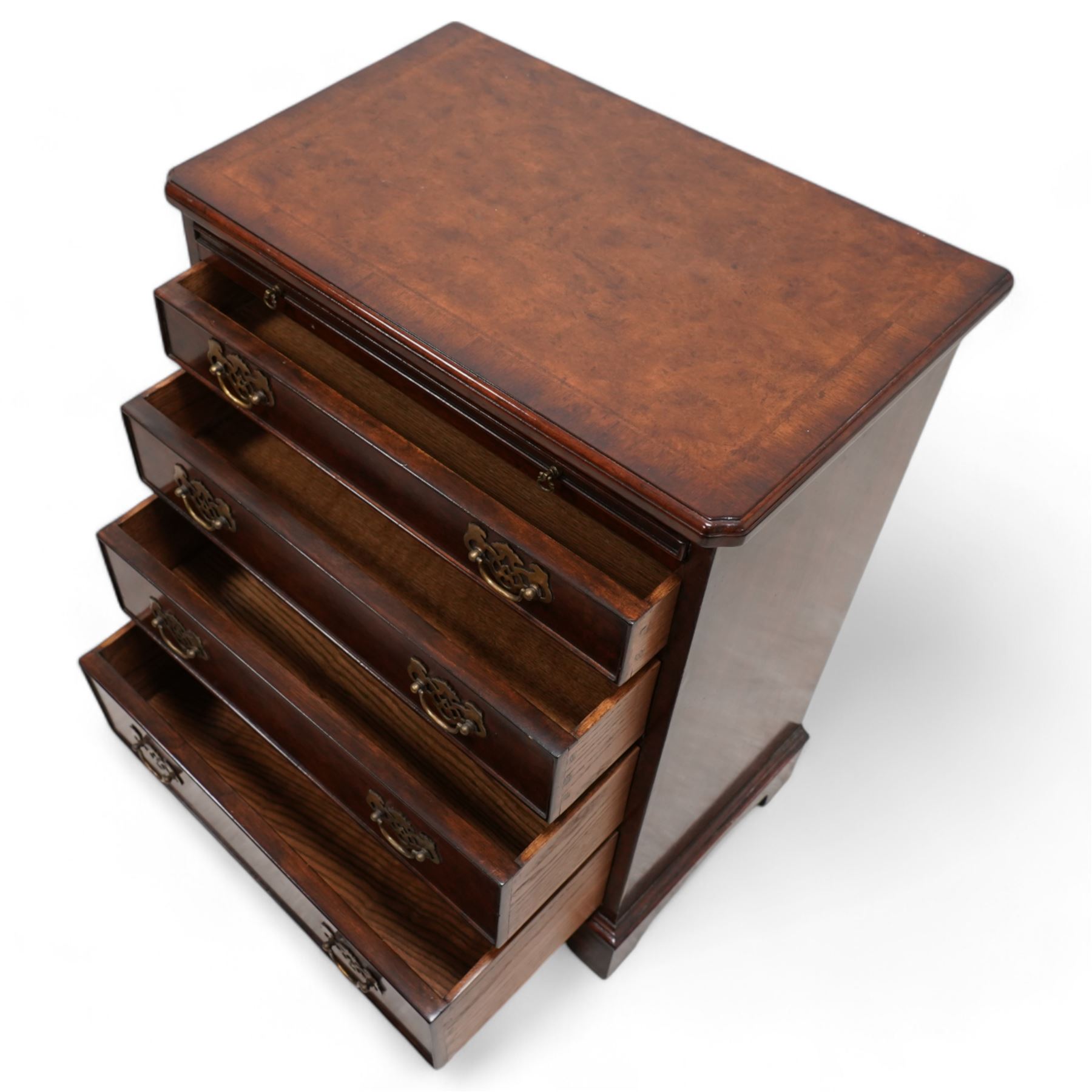 Small Georgian design walnut chest, rectangular moulded top with crossbanding and feather bands, shaped canted corners, slide over four graduating cock-beaded drawers, pierced brass handle plates, on bracket feet 