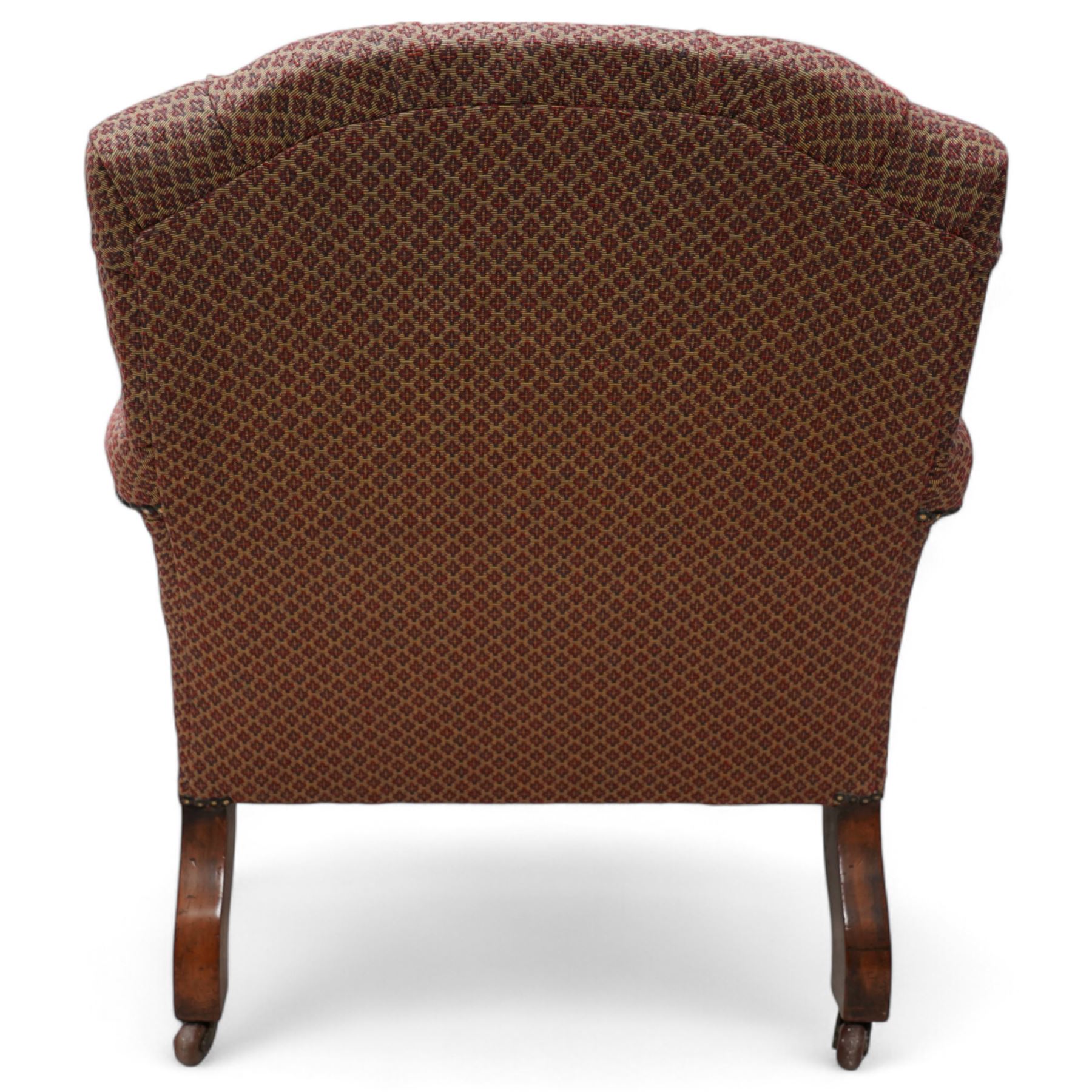 Late 19th century drawing room walnut framed open armchair, arched back over fluted and turned arm terminals and deep sprung seat, upholstered in buttoned maroon patterned fabric with stud detail on turned and fluted supports with castors