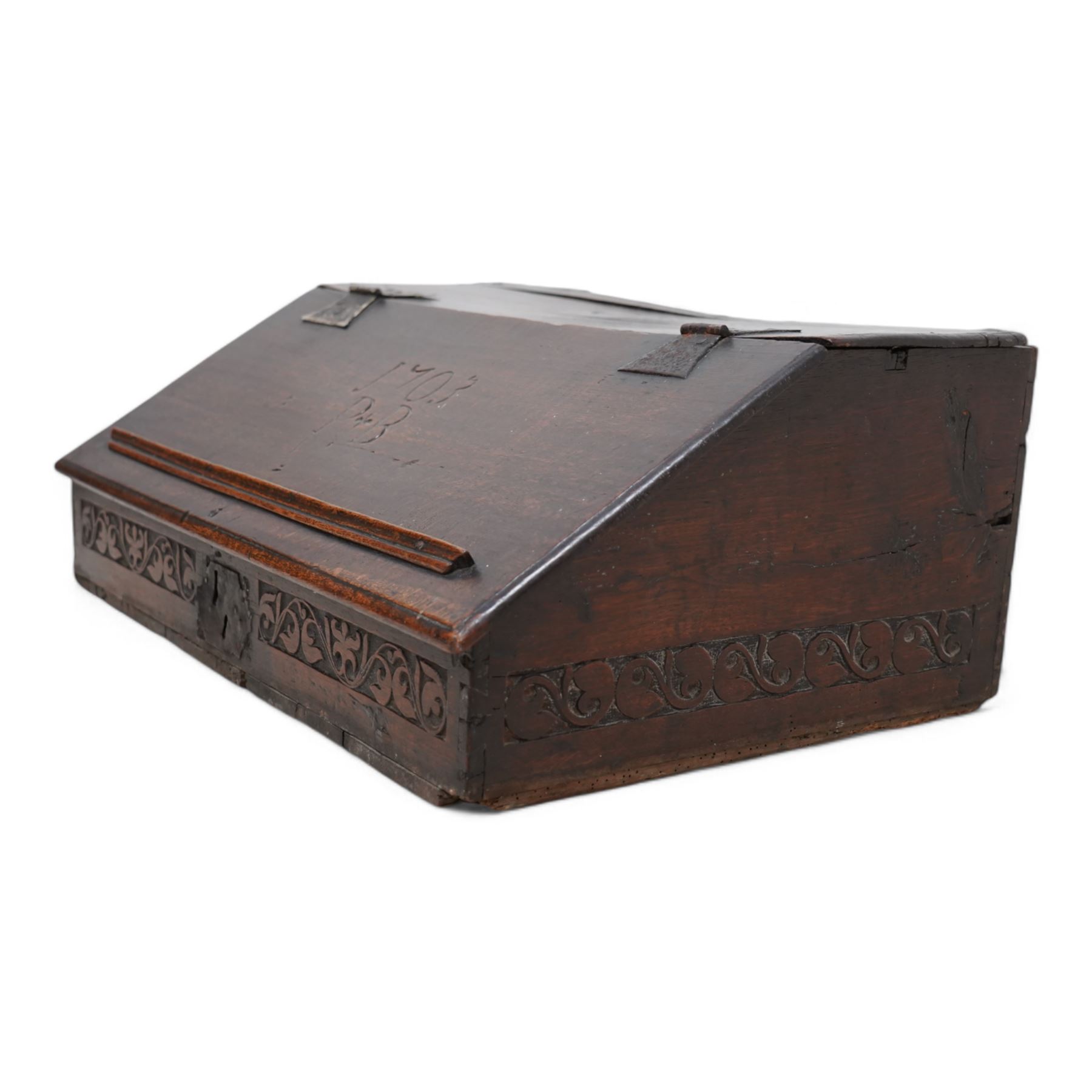 Early 18th century oak bible box, sloped hinged lid inscribed '1703 P.B', the front and sides carved with foliate scroll bands