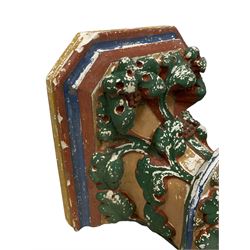 Two Victorian polychromed plaster cast corbels or wall brackets, canted rectangular tops over moulded edge and curled fruiting foliage