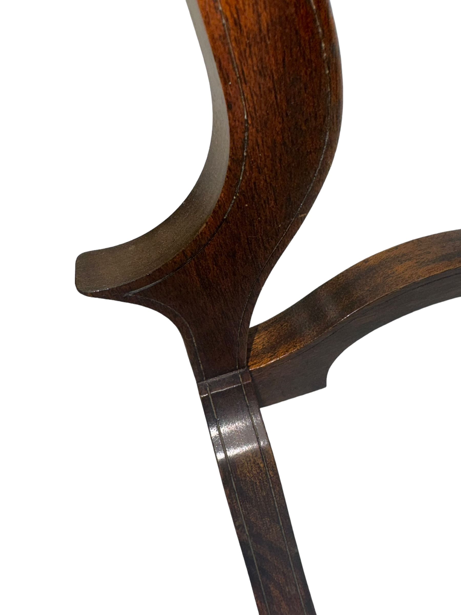 Edwardian mahogany shield-shaped dressing mirror, shaped frame with swivel function, on scroll supports connected by curved stretcher 